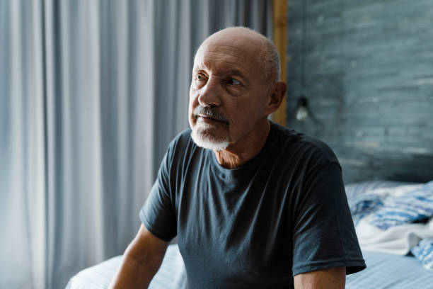 istock Contemplating wrinkled man sitting in bedroom 1273811543