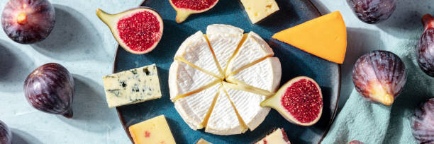 istock Cheeses panorama, a flat lay with figs, shot from above 1273813728