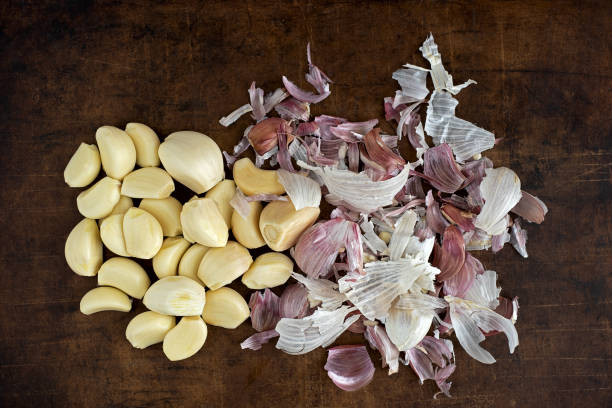 peeled cloves of garlic with peel stock photo