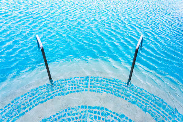 スチールレールと小さな波を持つ空のスイミングプール - resort swimming pool swimming pool poolside curve ストックフォトと画像