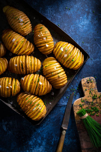 patate hassleback a fette di patate al forno tostato sale e erba cipolglia - roasted potatoes prepared potato herb food foto e immagini stock