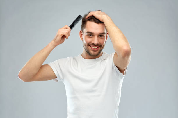 istock happy man brushing hair with comb over gray 1273825700