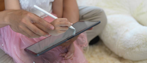istock Father teaching daughter, practice writing on digital tablet with stylus pen 1273825759