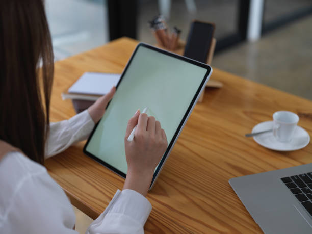 istock Female student using mock up digital tablet on wooden table in cafe 1273825839