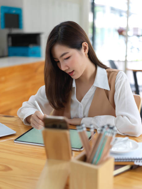 istock Female student concentrating on her project with stationery and tablet on table 1273826051