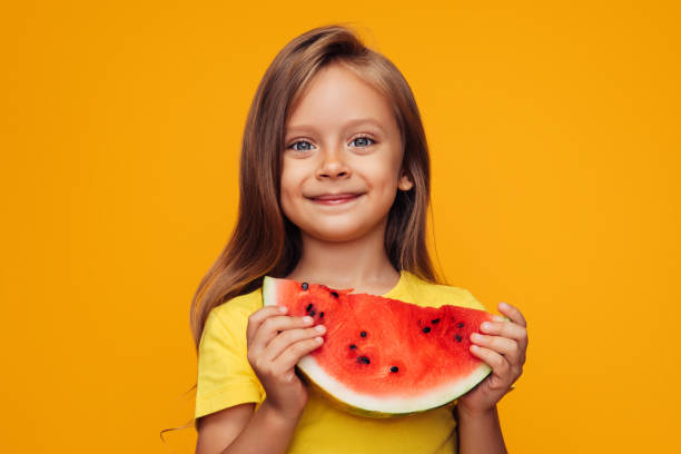 niña joven comiendo sandía - child food fruit childhood fotografías e imágenes de stock