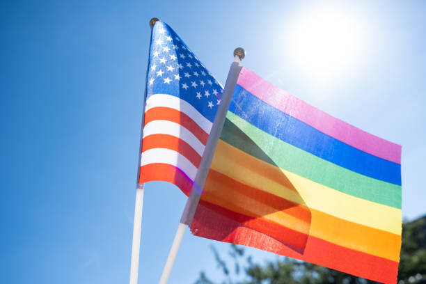 istock LGBT flag in a man's hand against a blue sky background 1273826431