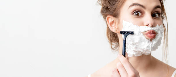 istock Woman shaving her face by razor 1273826442