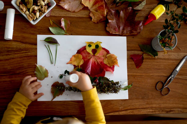 istock Sweet child, toddler boy, applying leaves using glue 1273827765