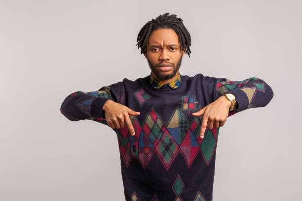istock Serious african guy pointing fingers down with concentrated strict face, time to act here and now 1273827924