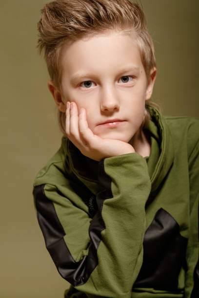istock serious boy sad on green background 1273829299