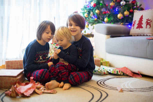 istock Happy children, opening presents on christmas day 1273830402