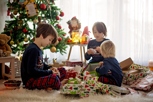 Happy children, opening presents on christmas day