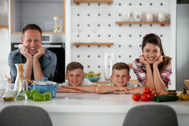 istock Mother and father making breakfast with sons. 1273833741