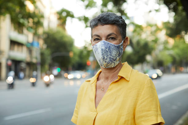 istock One woman wearing a protective face mask and looking at camera. 1273833789