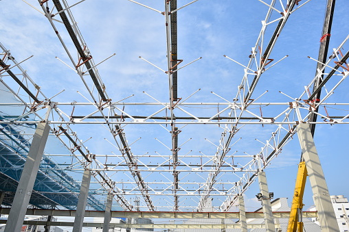 Steel structure roof truss frame installation by mobile crane under the construction building in the factory