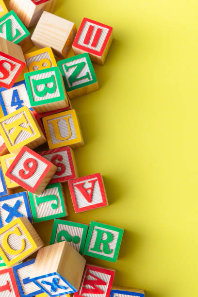 istock Toys: Alphabet Blocks on Yellow Background Still Life 1273835111