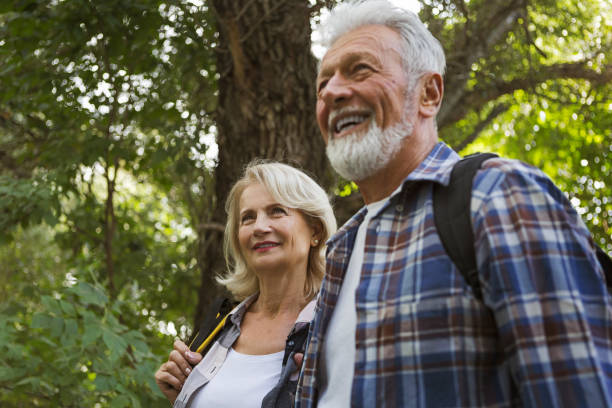 istock Senior couple hiking through the forest and exploring nature 1273836142