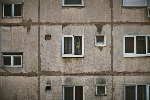 Oradea, Romania - January 8, 2019: A close view of an old communist apartment building in Oradea that was renovated with new insulated glass windows.