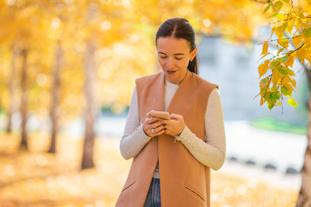 istock Fall concept - beautiful woman in autumn park under fall foliage 1273841071