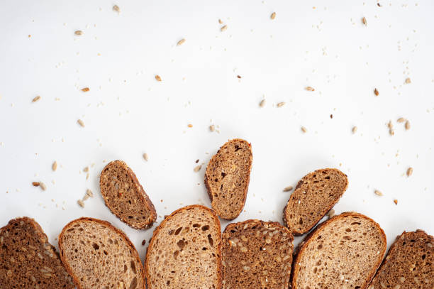 istock Composition of different whole grain bread, seeds and sesame seeds on a white background. Copy spase. Top view. 1273841324