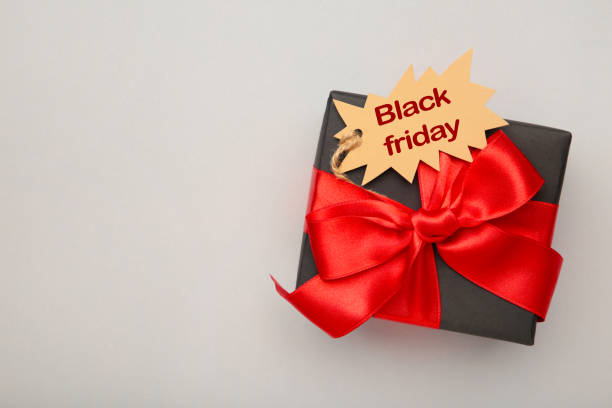 istock Black gift with sale tag on grey background. Black Friday sales discount composition. 1273841483