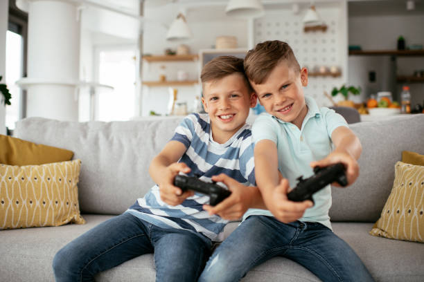 istock Young brothers having fun while playing video games in living room 1273841571