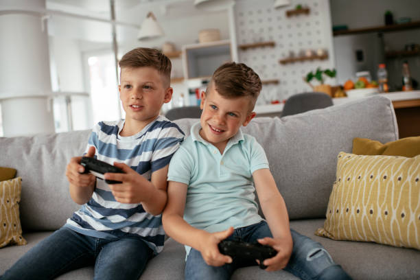 istock Young brothers having fun while playing video games in living room 1273841800