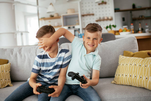 istock Young brothers having fun while playing video games in living room 1273841801