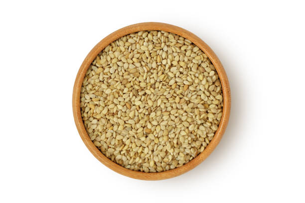 istock Sesame seeds in wooden bowl on white background 1273842821