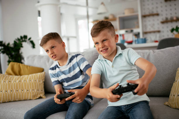 istock Young brothers having fun while playing video games in living room 1273843097