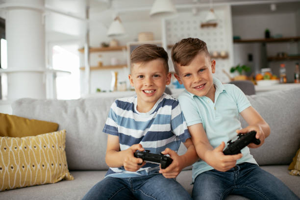 istock Young brothers having fun while playing video games in living room 1273843379