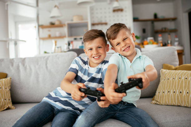 istock Young brothers having fun while playing video games in living room 1273843384