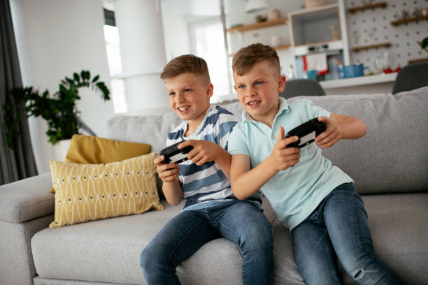 istock Young brothers having fun while playing video games in living room 1273844107