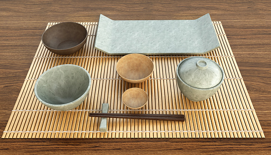 Japanese table setting. Concept image for traditional dining guide or oriental ceramics tableware set with main dish, side dishes, pickle, soup and chopsticks on bamboo mat. 3D rendering.