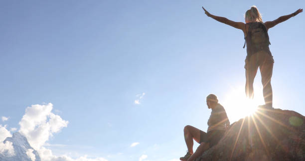 istock Female hikers relax on mountain ridge at sunrise 1273845467
