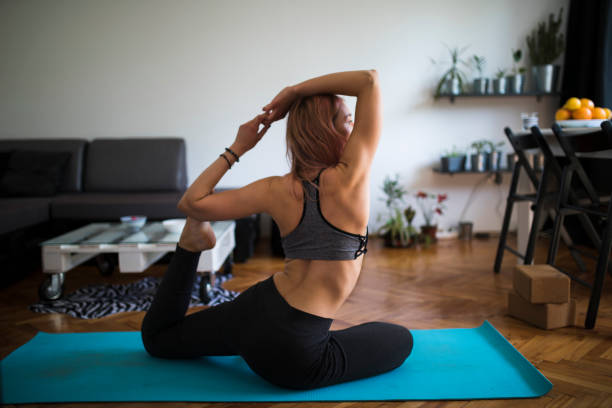 istock Young woman doing yoga at home 1273845893