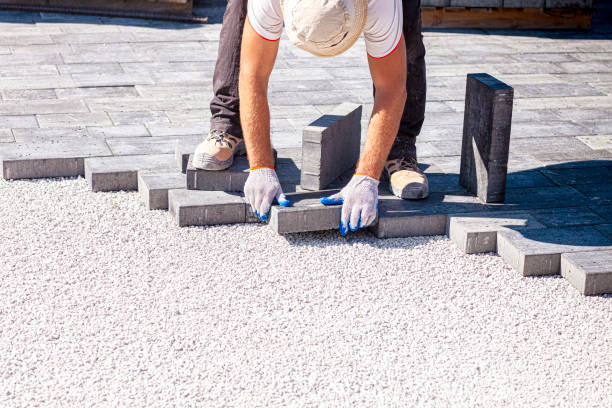 istock Paver arranges cement paving stones 1273847683