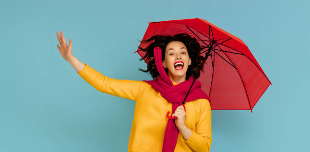 istock woman with umbrella on color background 1273849009