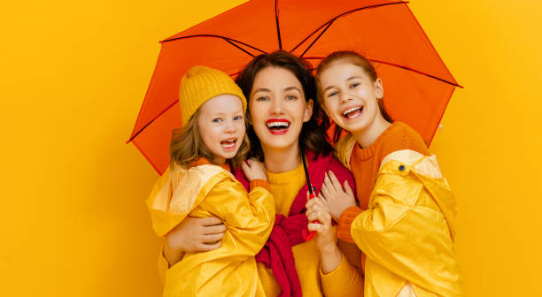 istock Family with umbrella on colored background. 1273849114