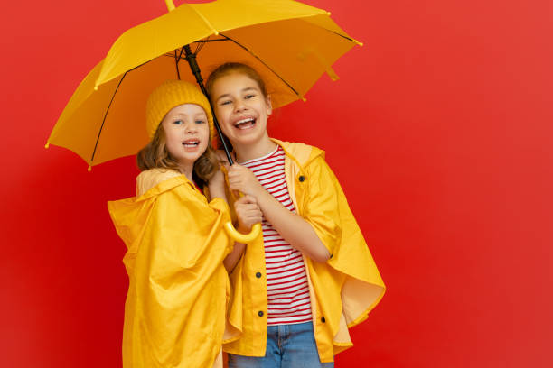 istock Kids with umbrella on colored background. 1273849116
