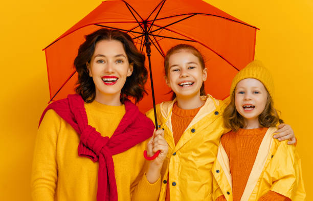 istock Family with umbrella on colored background. 1273849656