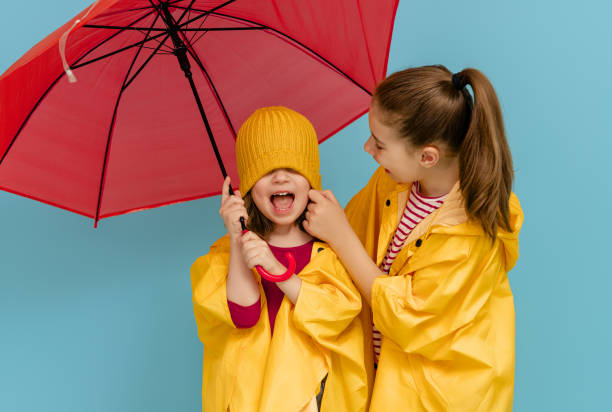 istock Kids with umbrella on colored background. 1273849658