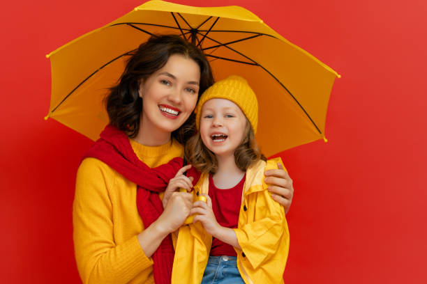 istock Family with umbrella on colored background. 1273849677