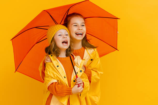 istock Kids with umbrella on colored background. 1273849693