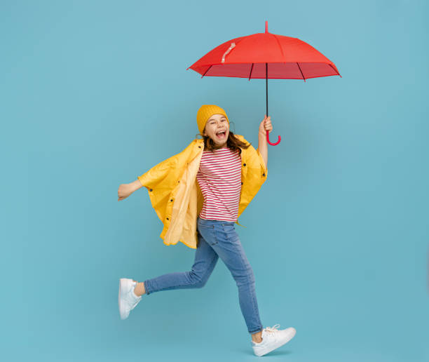 istock Kid with umbrella on colored background. 1273849753