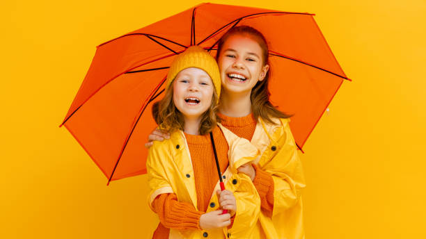 istock Kids with umbrella on colored background. 1273849802