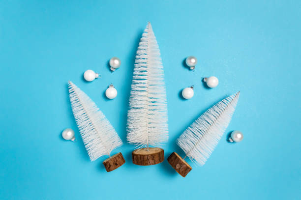 istock White Christmas trees and balls on blue background as minimal winter flat lay 1273850034
