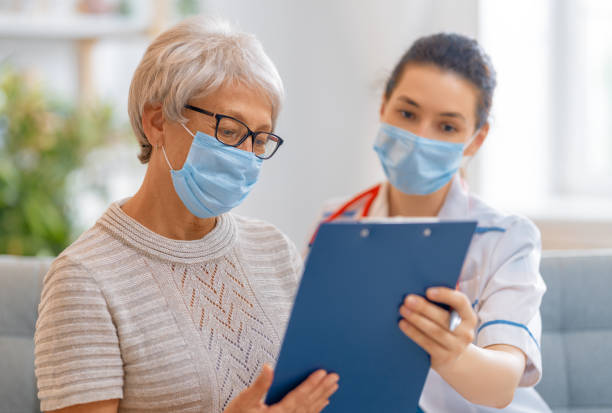 istock Doctor and senior woman wearing facemasks 1273852411
