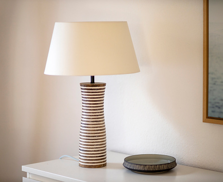 Stylish table lamp in the living room on the sideboard